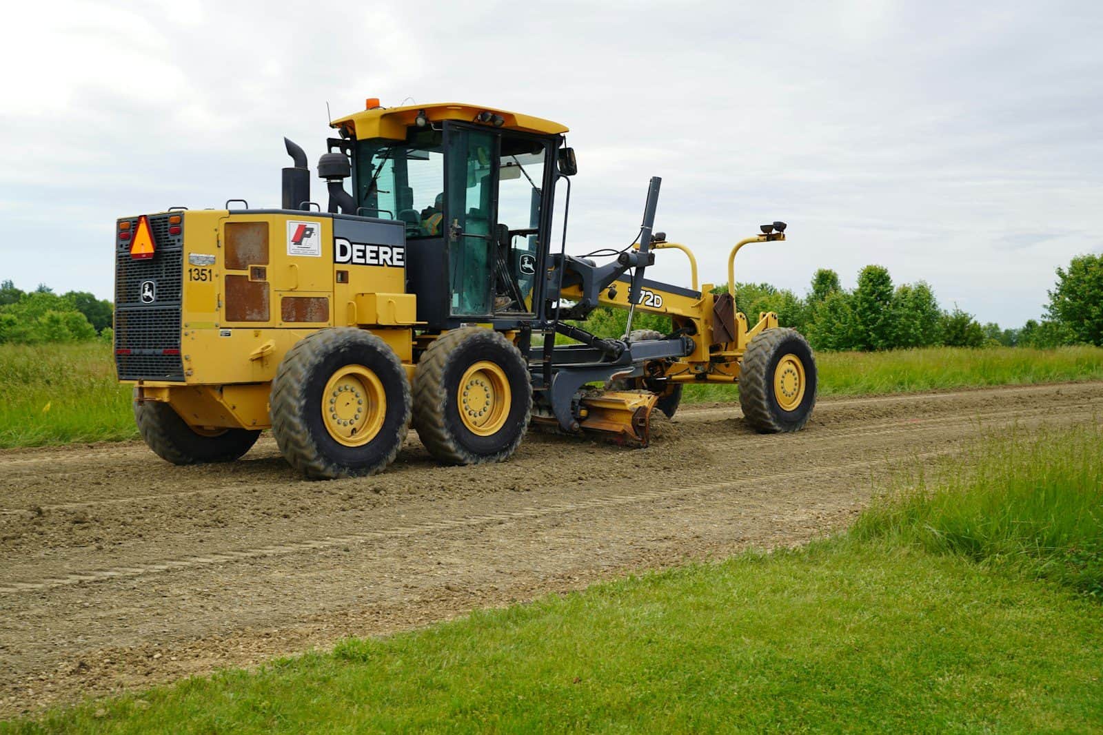 A motor grader with its blade set beneath the frame