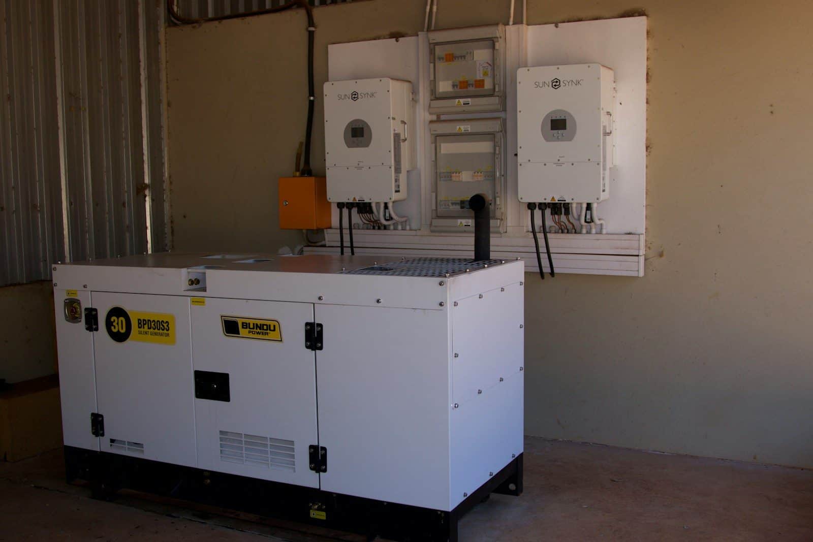 A canopied diesel generating set installed beside its switchgear
