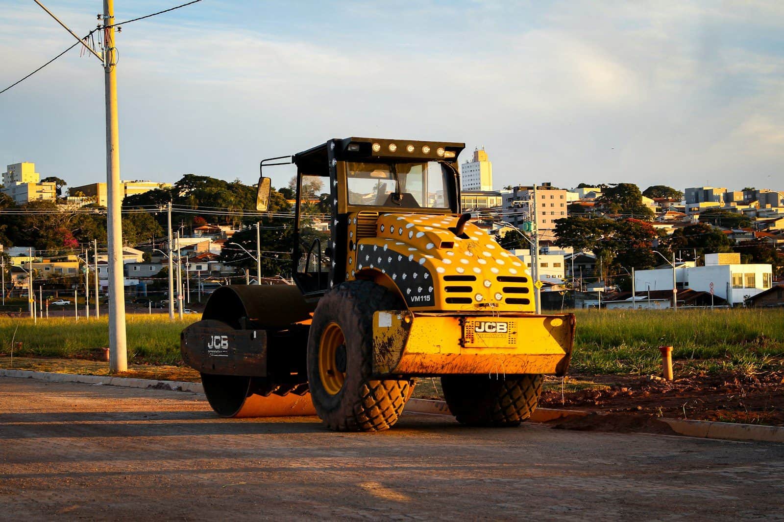 A single-drum vibratory roller standing on a prepared road base