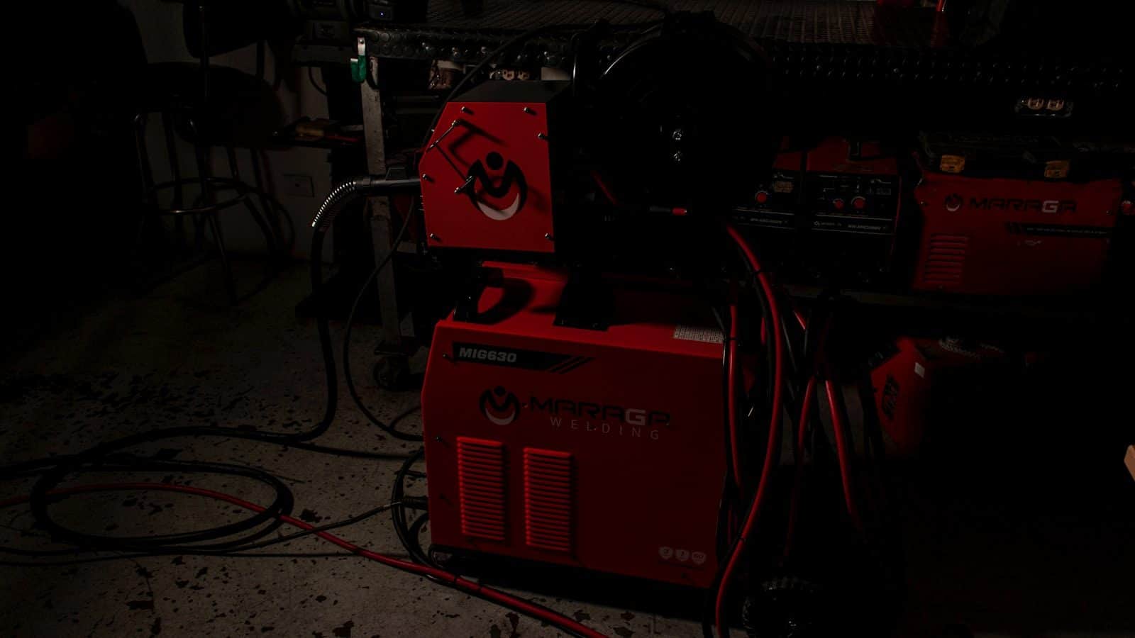 Welding power sources with their cable looms coiled in a workshop