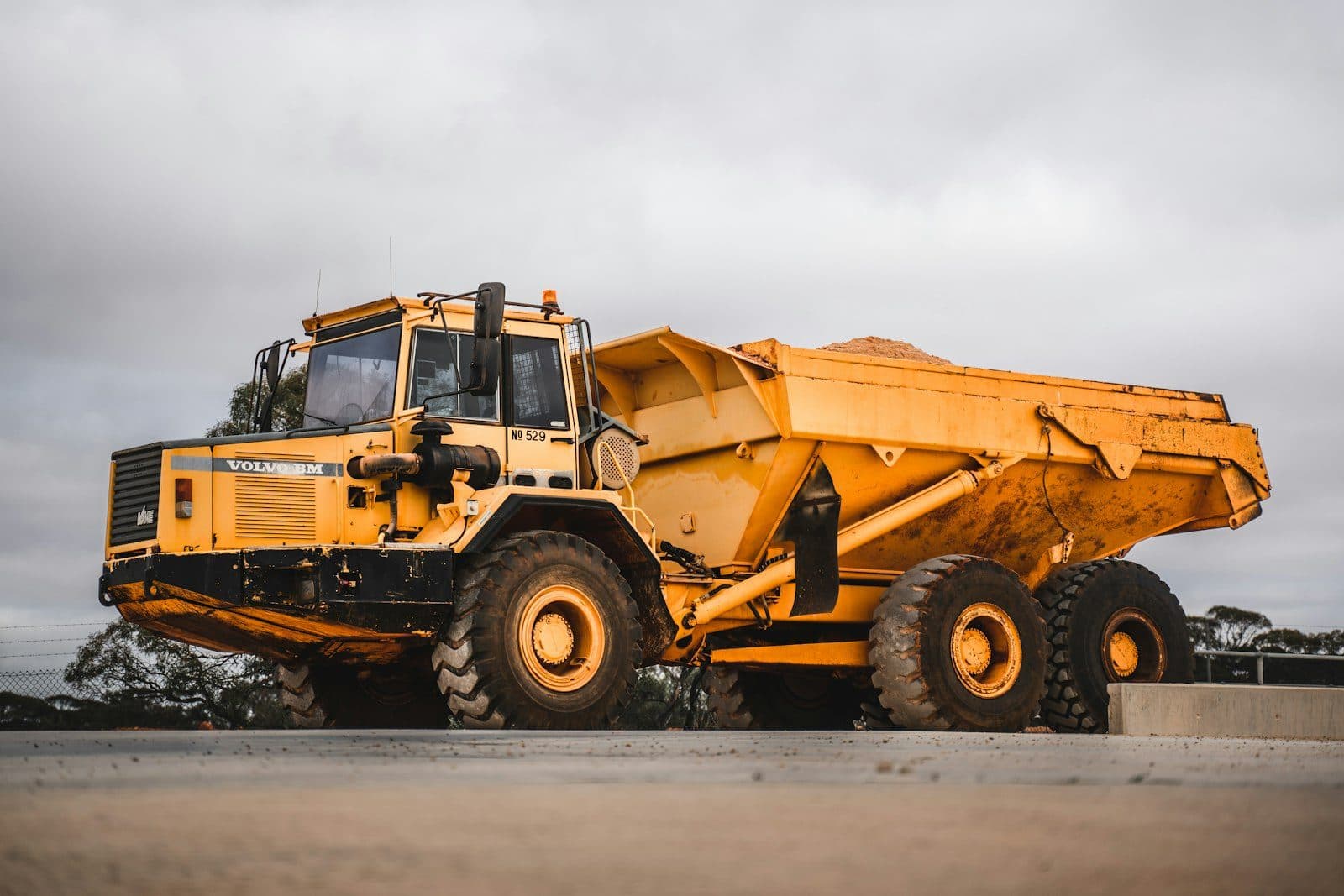 An articulated dump truck loaded with material on a haul road