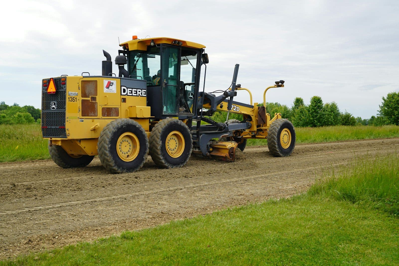 A motor grader with its blade set beneath the frame
