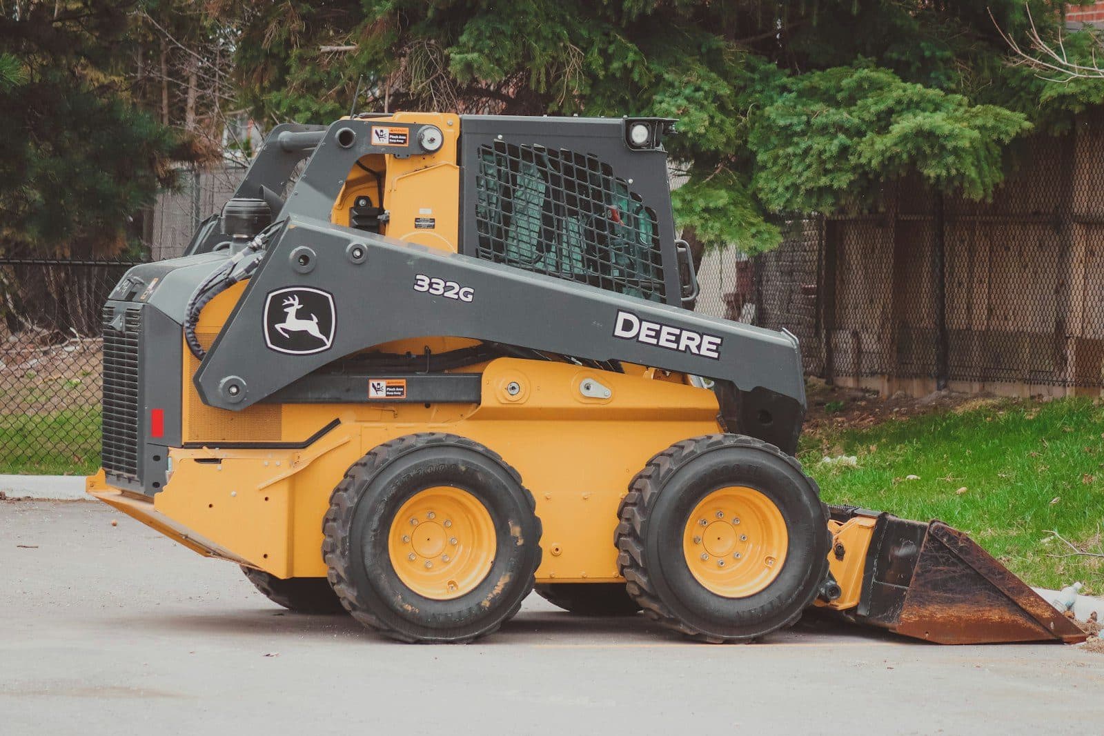 A compact skid steer loader with its bucket resting on the ground