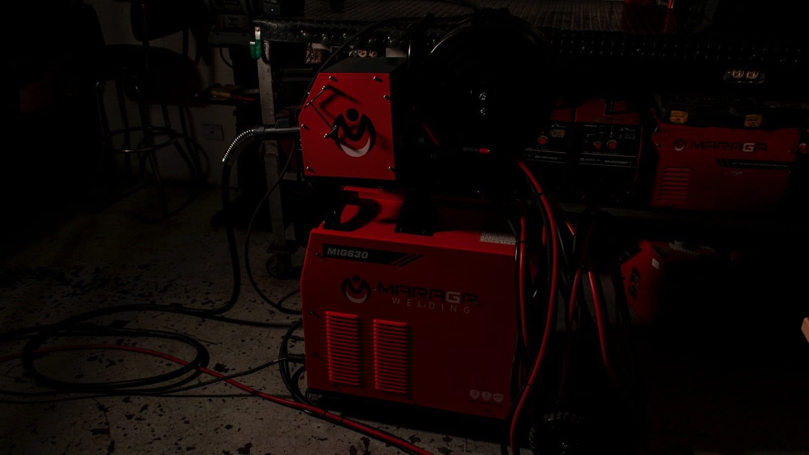 Welding power sources with their cable looms coiled in a workshop