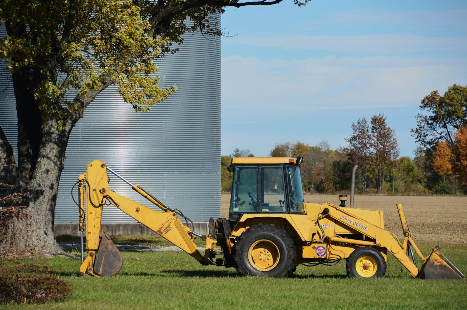 A backhoe loader with its rear arm folded and its front bucket down