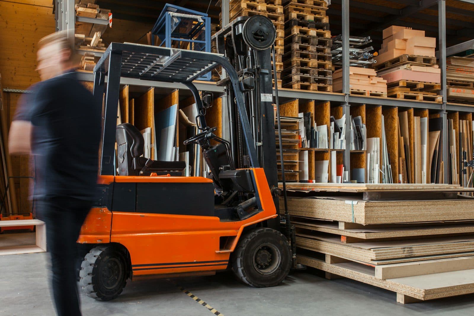 A counterbalance forklift with its mast raised in a materials yard